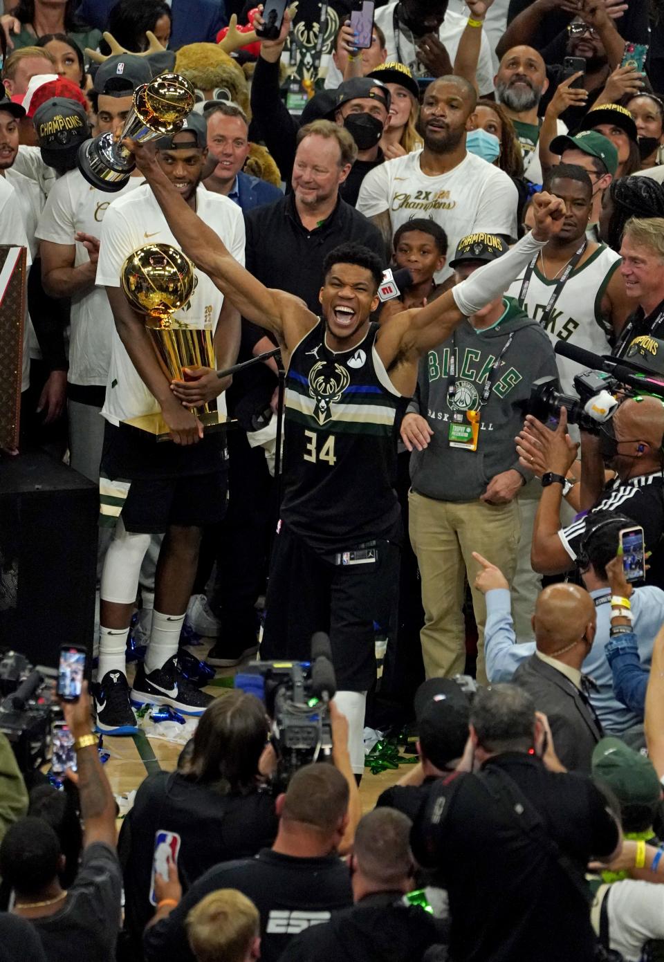 Giannis Antetokounmpo holds his NBA Finals MVP trophy and Khris Middleton holds the championship trophy after the Bucks won the 2021 title at Fiserv Forum.