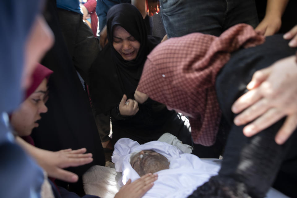 Relatives mourn over the body of Palestinian Hamas police officer, Wael Khalifa, 45, in the family home, during his funeral in the Buriej refugee camp, central Gaza Strip, Wednesday, Aug. 28, 2019. Khalifa and two other Hamas police officers were killed in explosions that ripped through police checkpoints in Gaza City overnight, Hamas' interior ministry said. (AP Photo/Khalil Hamra)