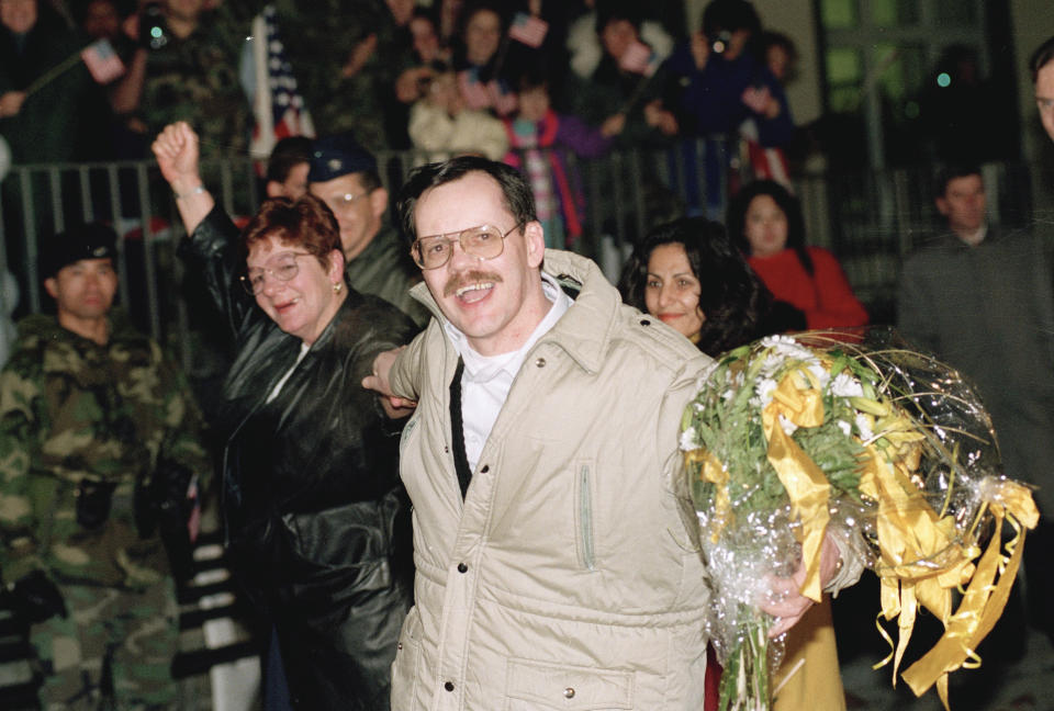 FILE - AP chief Middle East correspondent Terry Anderson, center, accompanied by his sister Peggy Say, left, and Madeleine Bassil, right, smiles broadly upon his arrival at the Wiesbaden Air Force hospital in Germany, Dec. 5, 1991, a day after being released by his abductors in Beirut, where he was held captive for almost seven years. Anderson died Sunday, April 21, 2024, at age 76. (AP Photo/Thomas Kienzle, File)