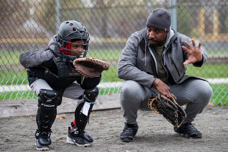 Monarchs' Jordan Daniel, 9, learns catching from Ethan Dunn during practice at Stoepel Park in Detroit on Tuesday, April 25, 2023.
