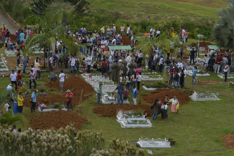 People attend the mass burial of the victims of a mudslide caused by heavy rains, at the cemetery in Mocoa, Putumayo department, Colombia on April 3, 2017