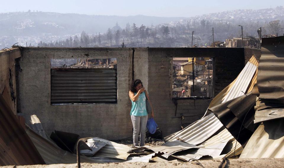 A resident reacts at the location where a forest fire burned several neighbourhoods in the hills in Valparaiso city