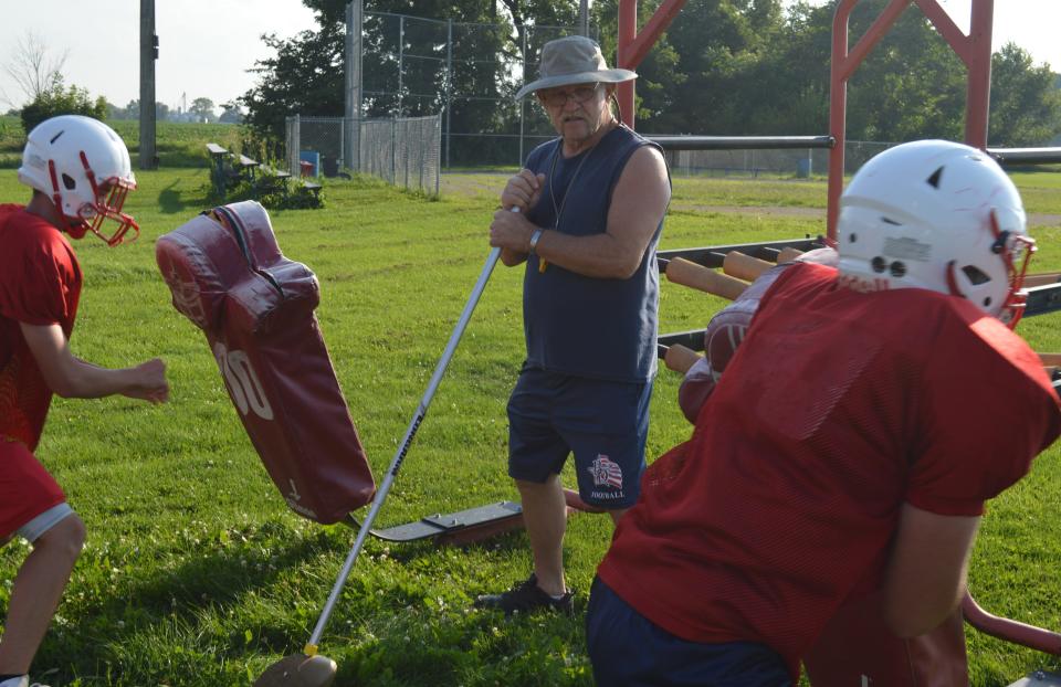 Britton Deerfield assistant coach John Johnson runs a drill with the lineman during a practice this summer.