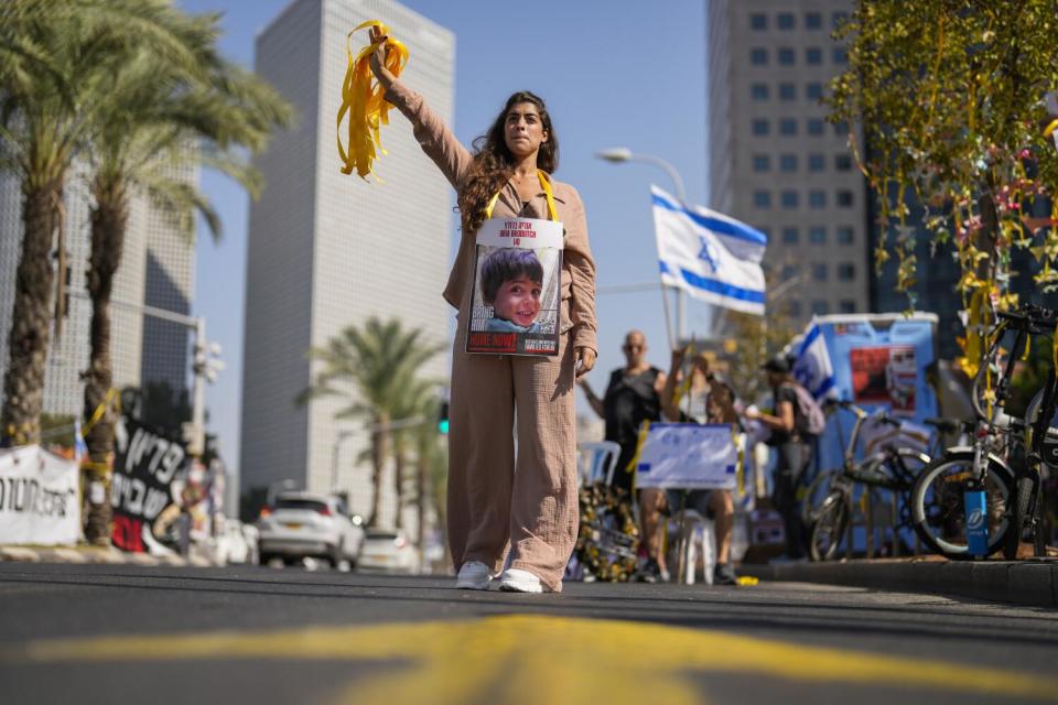 A woman holds a photo of a child who was abducted during the Hamas attack on Israel,