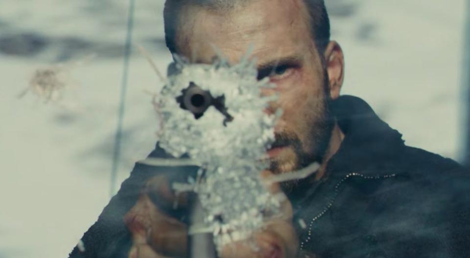 Curtis pointing a rifle out of a hole in a cracked window in "Snowpiercer"