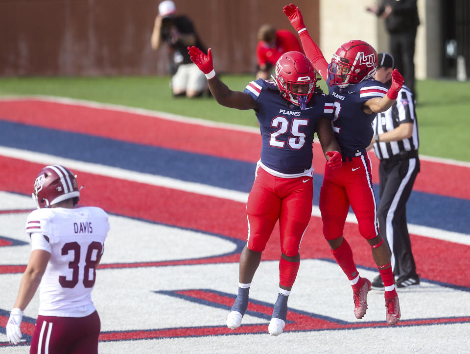 Liberty wide receiver Kevin Shaa (2) celebrates his touchdown with teammate running back Peytton Pickett (25) as Massachusetts safety Tanner Davis (38) walks away during the first half of a NCAA college football game on Friday, Nov. 27, 2020, at Williams Stadium in Lynchburg, Va. (AP Photo/Shaban Athuman)