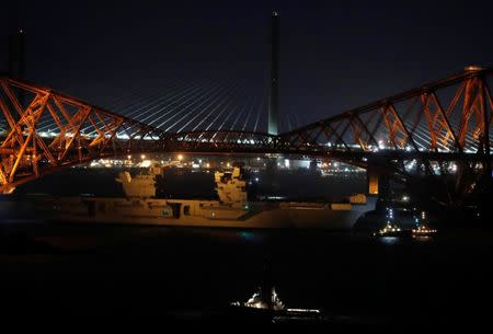 The British Aircraft carrier HMS Queen Elizabeth is guided by tugs under the Forth Rail Bridge as it departs for sea trials, Scotland, Britain June 26, 2017. REUTERS/Russell Cheyne