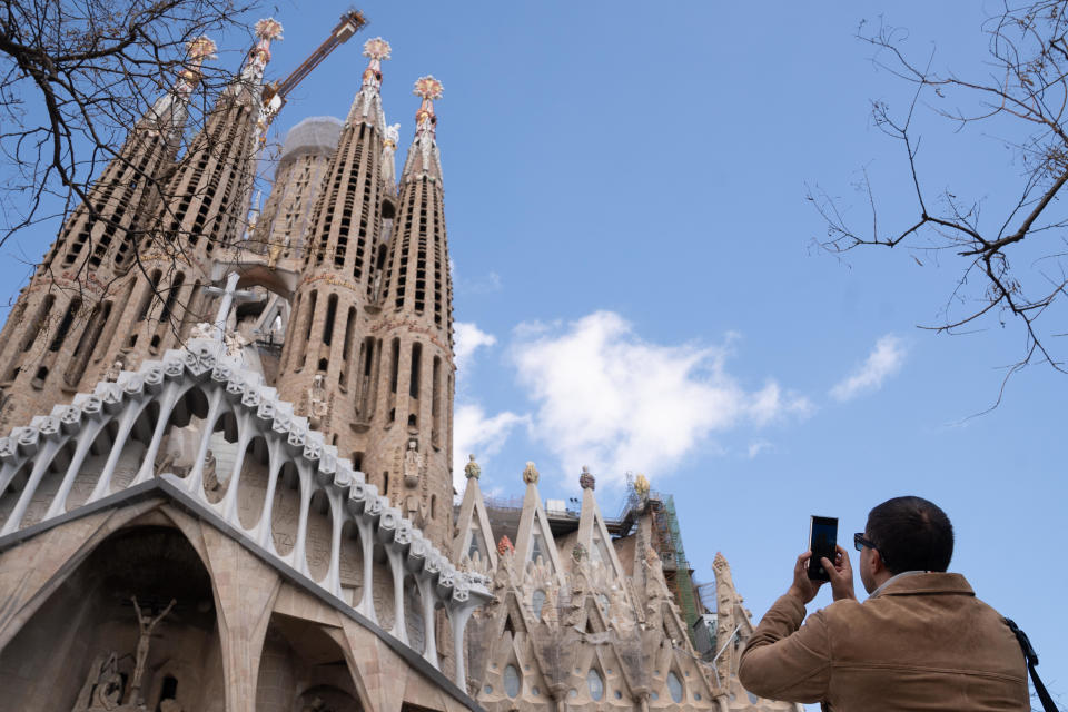 A tourist takes a photo next to the Sagrada Familia, March 15, 2024, in Barcelona. / Credit: David Zorrakino/Europa Press via Getty Images