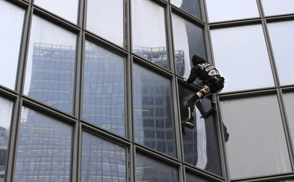 French urban climber Alain Robert, well known as "Spiderman", climbs up the Total tower in the Paris business district of La Defense, Monday, Jan 13, 2020, in support of the transport strikes. (AP Photo/Michel Euler)