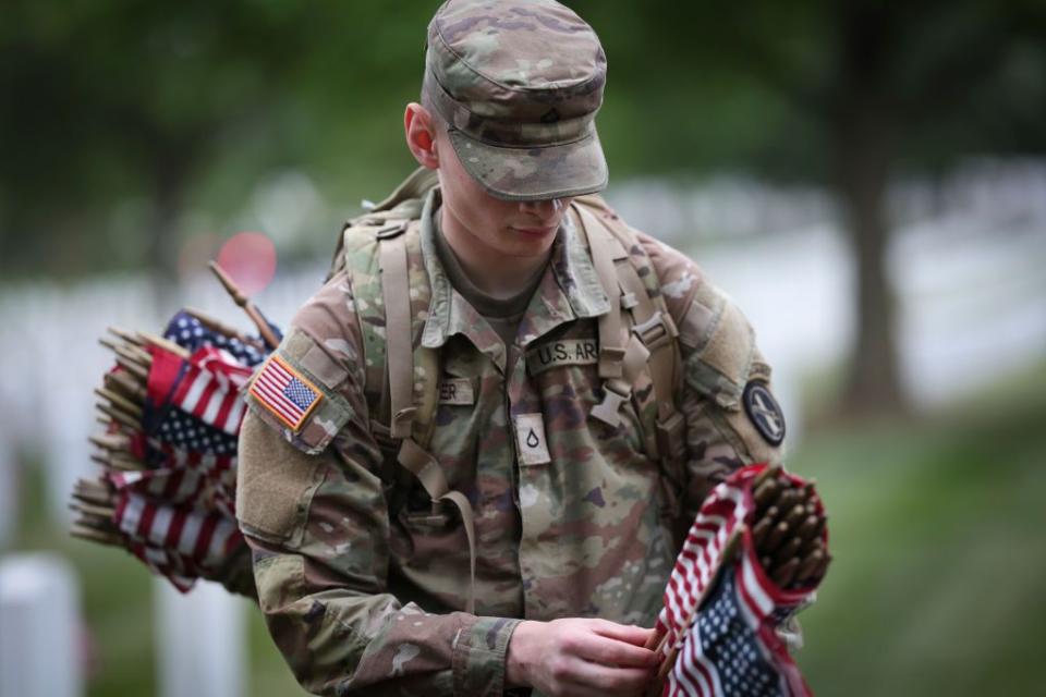 ARLINGTON, VIRGINIA - MAY 25: Members of the 3rd U.S. Infantry Regiment place flags at the headstones of U.S. military personnel buried at Arlington National Cemetery, in preparation for Memorial Day, on May 25, 2023 in Arlington, Virginia. More than 1000 service members entered the cemetery at pre-dawn hours to begin the process of placing a flag in front of more than 270,000 headstones. (Photo by Win McNamee/Getty Images)