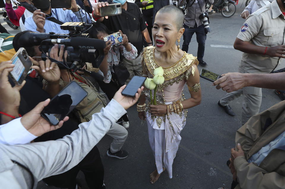 Theary Seng, a Cambodian-American lawyer, dressed in a traditional Khmer Apsara dance costume, speaks to media as she arrives to continue her trial in the municipal court in Phnom Penh, Cambodia, Tuesday, Dec. 7, 2021. Seng and over 40 other defendants charged with treason for taking part in nonviolent political activities were summoned back to court Tuesday to continue their trial that had been suspended since November 2020 due to the coronavirus. (AP Photo/Heng Sinith)
