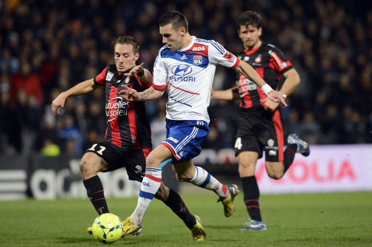 Lyon's forward Anthony Reveillere (C) fights for the ball with Nice's forward Eric Bautheac during their French L1 football match on December 22, 2012, at the Gerland stadium in Lyon. Lyon defeated Nice 3-0 on Saturday to go level with leaders Paris Saint-Germain on 38 points as Ligue 1 prepared to head into its winter hibernation