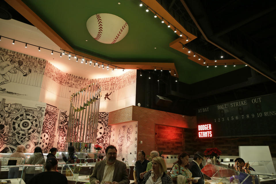 People make their way through a lunch buffet during the opening of Lefty O'Doul's new 20,000 square foot Baseball Ballpark Buffet & Café at Fisherman's Wharf, Tuesday, Nov. 20, 2018, in San Francisco. The popular Union Square bar and restaurant Lefty O'Doul's closed in January 2017 due to a dispute between the owner and his landlord, but now the restaurant has returned on the wharf. Lefty O'Doul's was named after the well-known and respected New York Giants star outfielder. With a .398 batting average, he boasted the highest average out of any outfielder in the 20th century. (AP Photo/Eric Risberg)