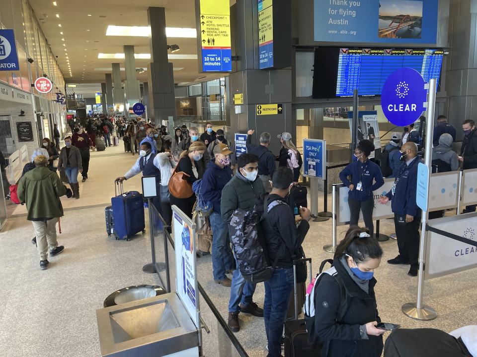 Travelers stand in line at a TSA security checkpoint at Austin-Bergstrom International Airport Friday, Feb. 19, 2021, in Austin, Texas. Temperatures dropped into the single digits this week as snow shut down air travel and grocery stores. (AP Photo/Ashley Landis)