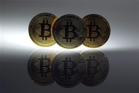 Mock Bitcoins are displayed on a table in an illustration picture taken in Berlin in this January 7, 2014 file photo. Mt. Gox, once the world's biggest bitcoin exchange, looked to have essentially disappeared on February 25, 2014, with its website down, its founder unaccounted for and a Tokyo office empty bar a handful of protesters saying they had lost money investing in the virtual currency. REUTERS/Pawel Kopczynski/File