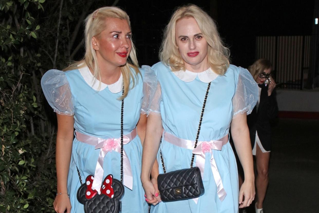 West Hollywood, CA - Rebel Wilson and girlfriend Ramona Agruma look smitten as they hold hands on their way to Halloween party in LA while dressed up as the creepy twins from The Shining. Pictured: Ramona Agruma, Rebel Wilson BACKGRID USA 30 OCTOBER 2022 USA: +1 310 798 9111 / usasales@backgrid.com UK: +44 208 344 2007 / uksales@backgrid.com *UK Clients - Pictures Containing Children Please Pixelate Face Prior To Publication*