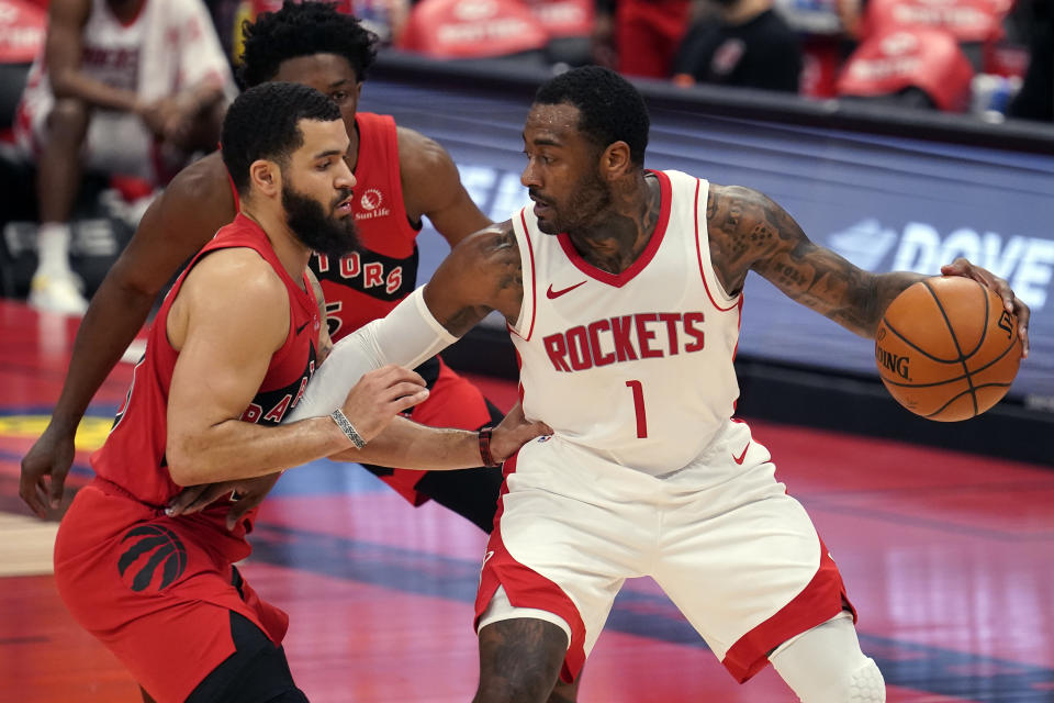 Houston Rockets guard John Wall (1) holds off Toronto Raptors guard Fred VanVleet (23) and forward Stanley Johnson (5) during the first half of an NBA basketball game Friday, Feb. 26, 2021, in Tampa, Fla. (AP Photo/Chris O'Meara)