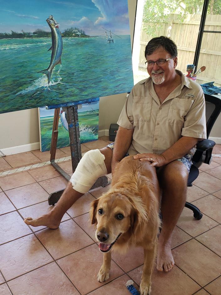 Mark Johnson, 61, a marine artist from Port St. Lucie, is glad he can smile alongside his faithful golden retriever, Rex, after being grabbed by an alligator behind his home on Sept. 13, 2020.