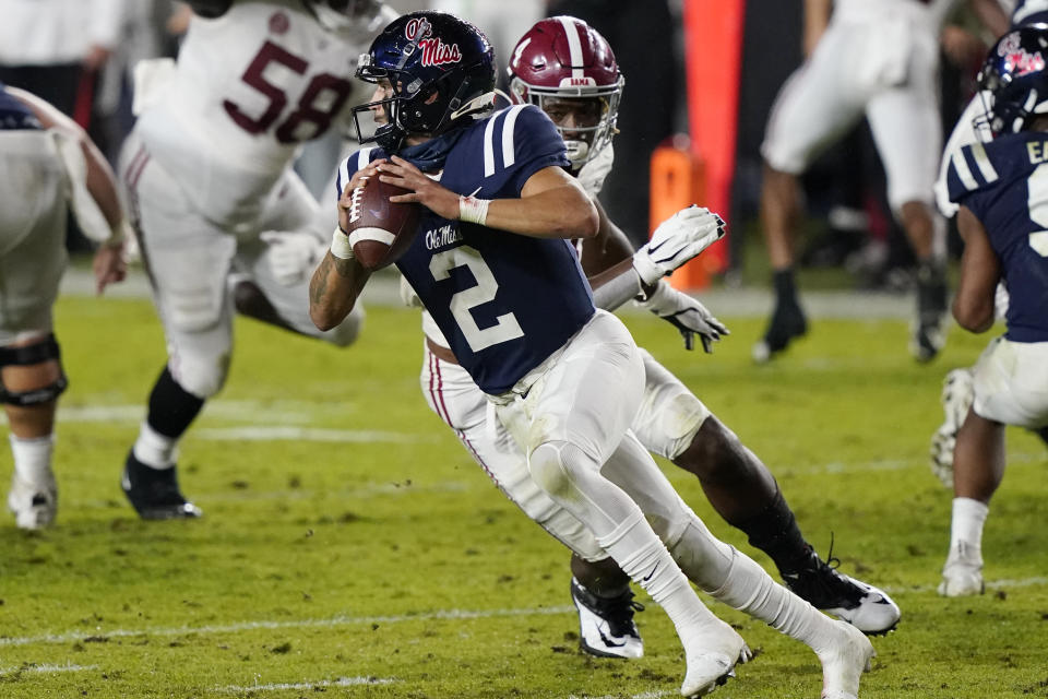 Mississippi quarterback Matt Corral (2) avoids a tackle by Alabama's Christopher Allen as he looks to pass during the first half of an NCAA college football game in Oxford, Miss., Saturday Oct. 10, 2020. Alabama won 63-48.(AP Photo/Rogelio V. Solis)