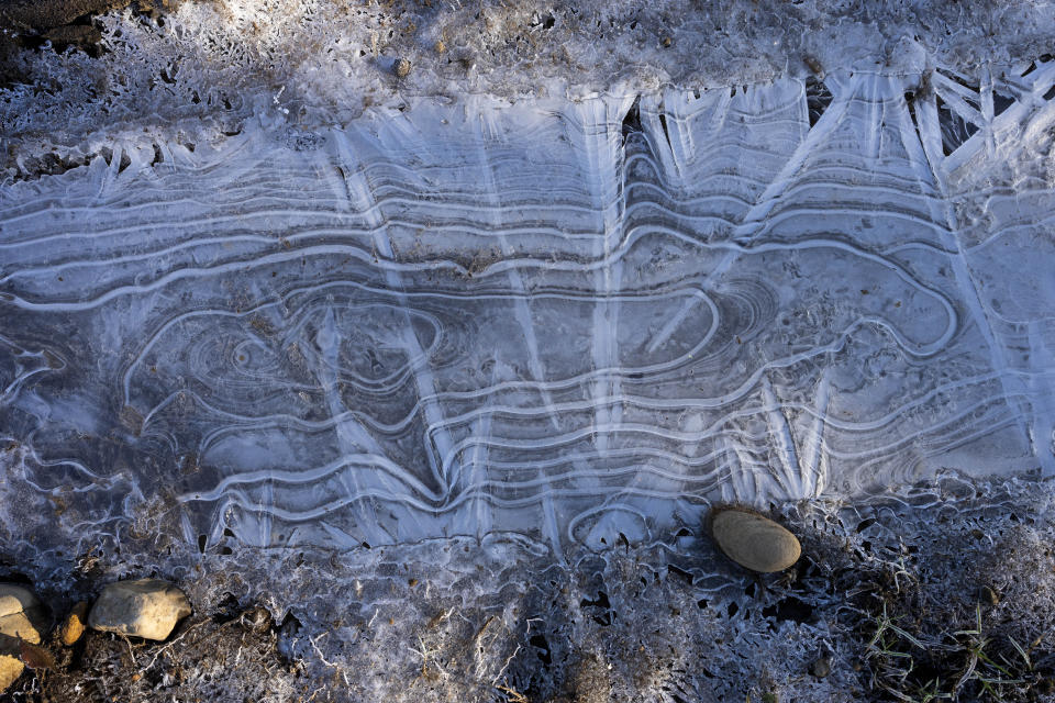 Frost patterns cover a patch of ground near the home of Millaray Huichalaf, a Mapuche machi, or healer and spiritual guide, in Carimallin, southern Chile, on Saturday, June 25, 2022. (AP Photo/Rodrigo Abd)