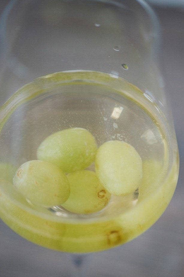 Frozen grapes in a glass of white wine.