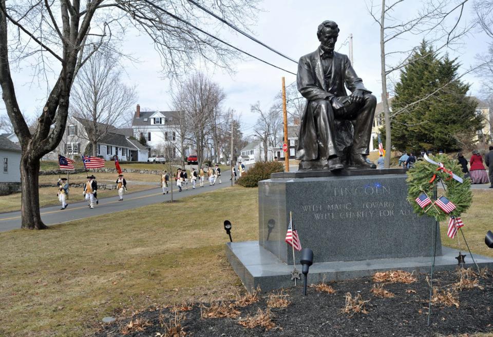 The Hingham Militia marches past the President Abraham Lincoln statue at Fountain Square during the Lincoln Day celebration in Hingham on Saturday, Feb. 19, 2022.