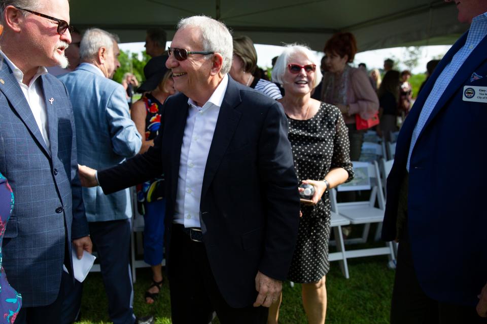 Jay and Patty Baker, at center, talk with community members after Baker Park's dedication ceremony, Tuesday, Oct. 29, 2019, in Naples. 