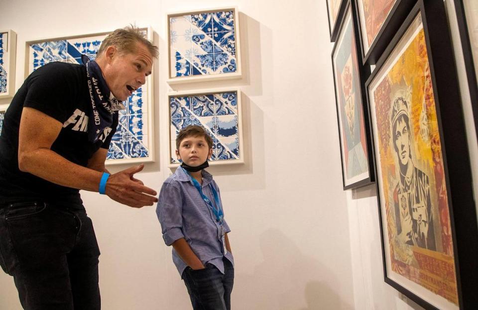 Street artist Shepard Fairey talks art with 10-year-old painter Andres Valencia at Art Miami on Tuesday.