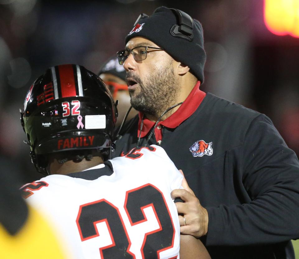 McKinley head coach Antonio Hall talks with Bulldogs linebacker E.J. Bankston at GlenOak, Oct. 14, 2022.