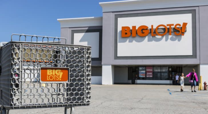 Photo of a Big Lots (BIG) store shot from the parking lot with a shopping cart in the foreground and clear blue sky in the background. BIG stock