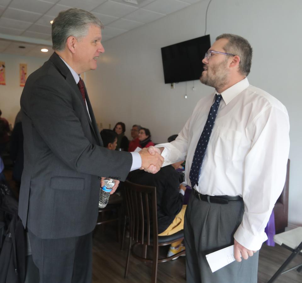 Summit County Councilman Jeff Wilhite, left, greets fellow Akron mayoral candidate Keith Mills before a forum Saturday.