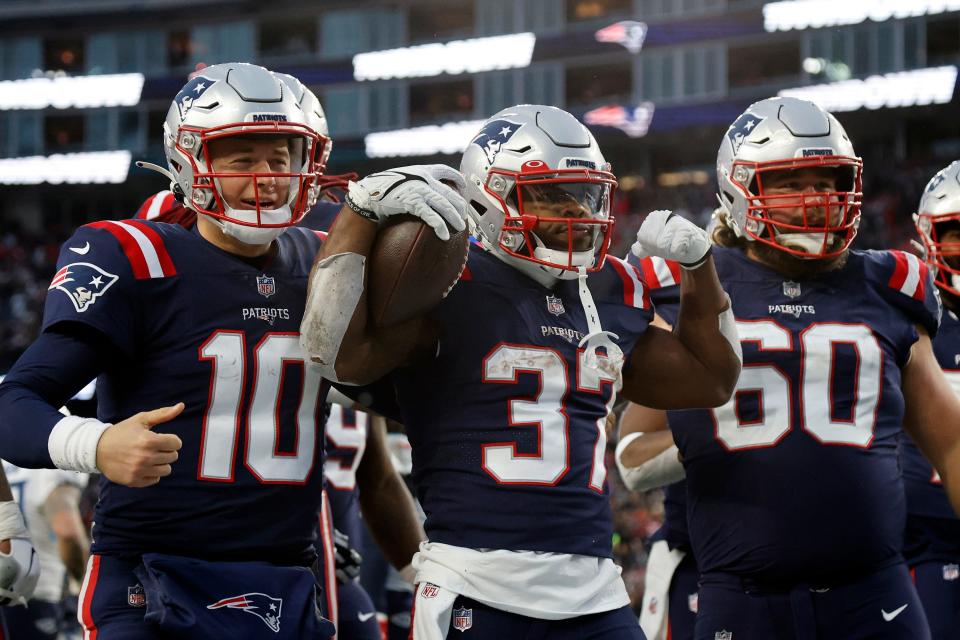 Patriots running back Damien Harris, center, celebrates with teammates Mac Jones, left, and David Andrews after scoring a touchdown against the Tennessee Titans on Nov. 28 in Foxboro.