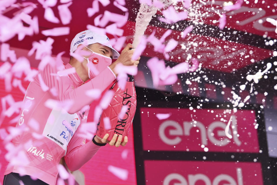 Hungary's Attila Valter wears the pink jersey of the race overall leader as he celebrates on the podium after completing the eighth stage of the Giro d'Italia cycling race, from Foggia to to Guardia Sanframondi, Italy, Saturday, May 15, 2021. (Massimo Paolone/LaPresse via AP)