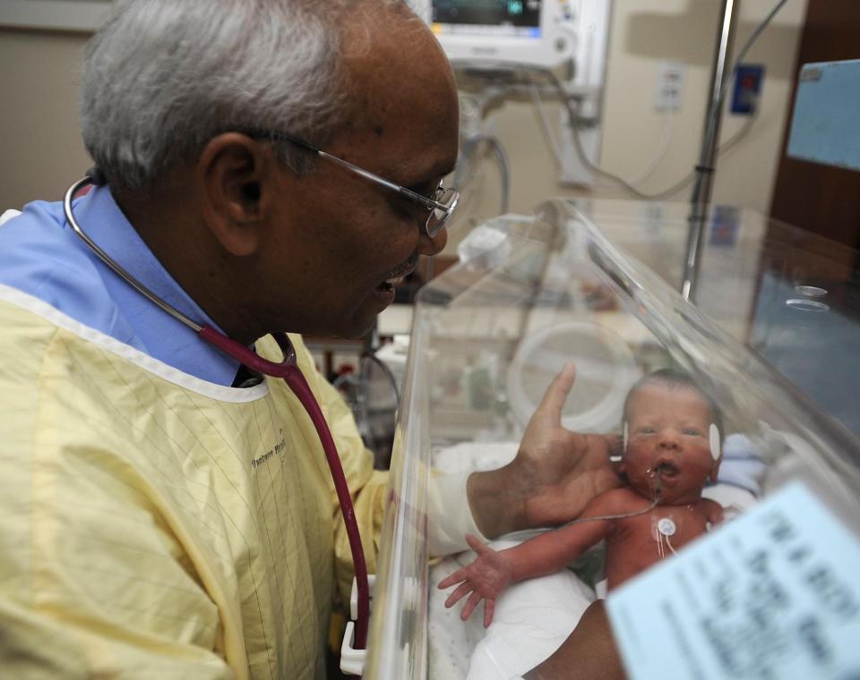 Dr. Sam Voora, shown in this July 2010 file photo, holds a prematurely born infant in Saint Vincent Hospital's neonatal intensive care unit. Voora, now 75, is one of many Erie physicians who have retired recently. ERIE TIMES-NEWS FILE PHOTO