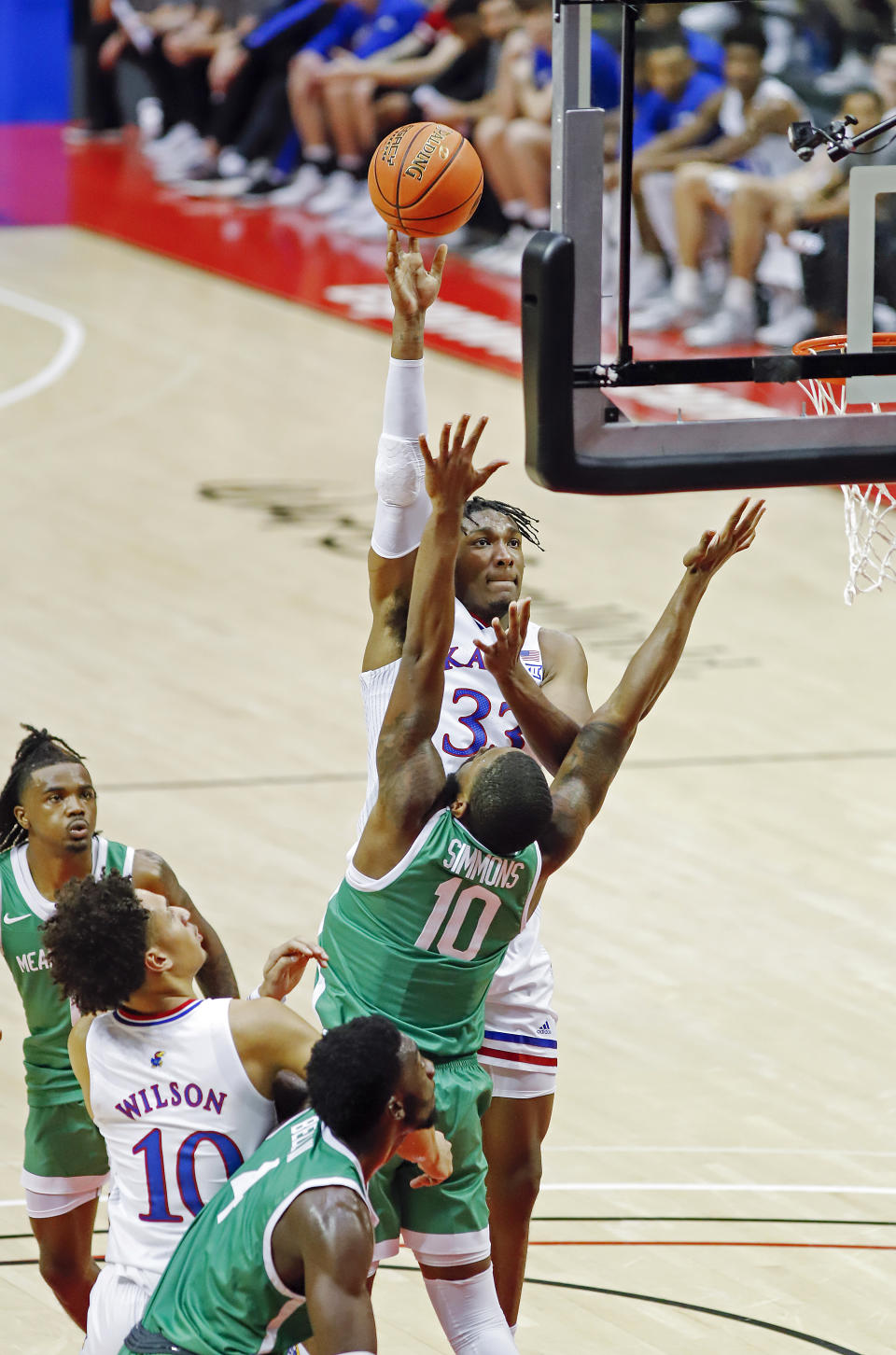 Kansas forward Jalen wilson, left, looks on as teammate David McCormack lays up a shot in over North Texas forward Jahmiah Simmons (10) during the first half of a NCAA college basketball game Thursday, Nov. 25, 2021, in Orlando, Fla. (AP Photo/Jacob M. Langston)