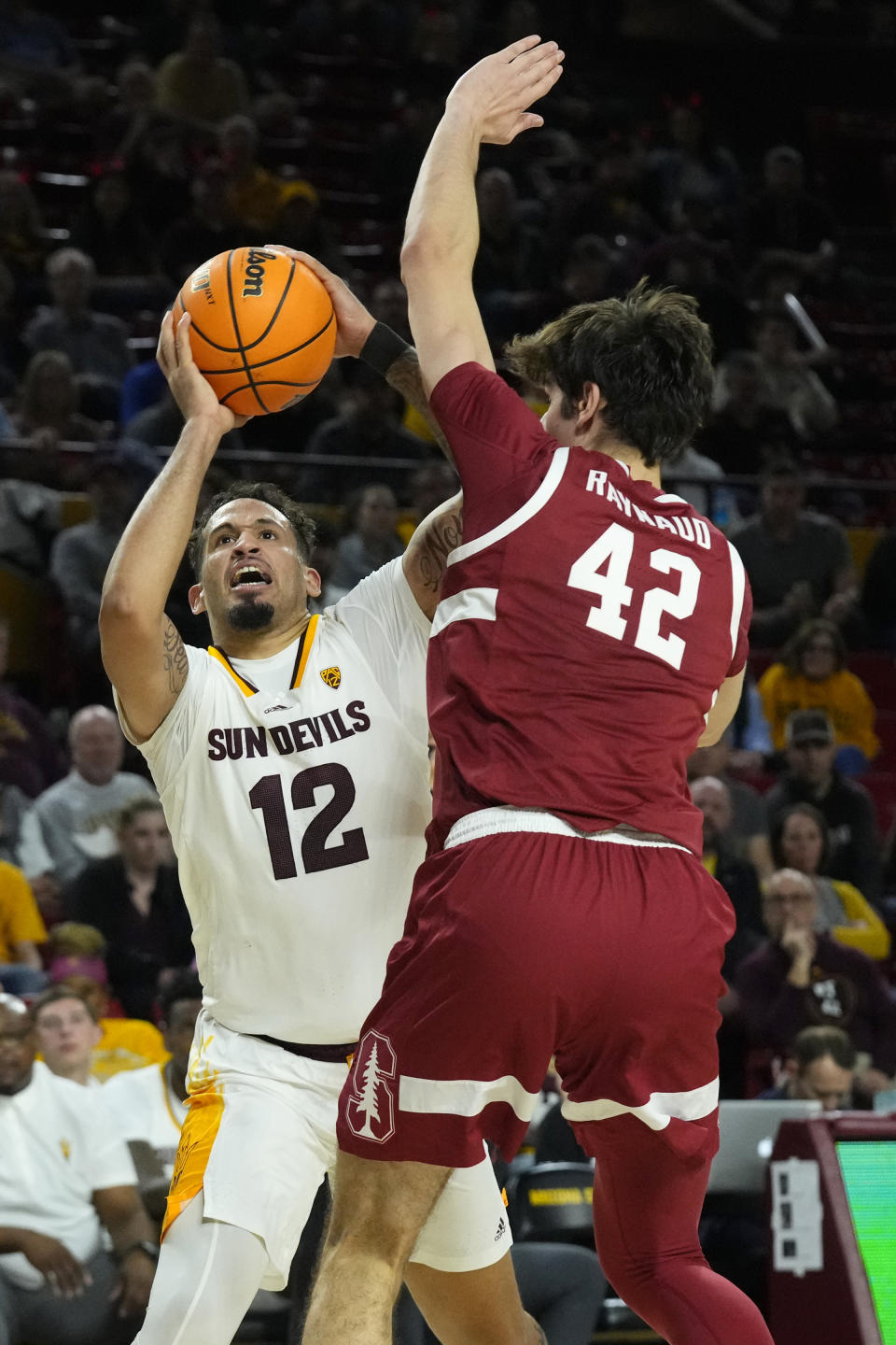 Arizona State guard Jose Perez (12) tries to shoot over Stanford Cardinal forward Maxime Raynaud (42) during the second half of an NCAA college basketball game Thursday, Feb. 1, 2024, in Tempe, Ariz. Stanford won 71-62. (AP Photo/Ross D. Franklin)