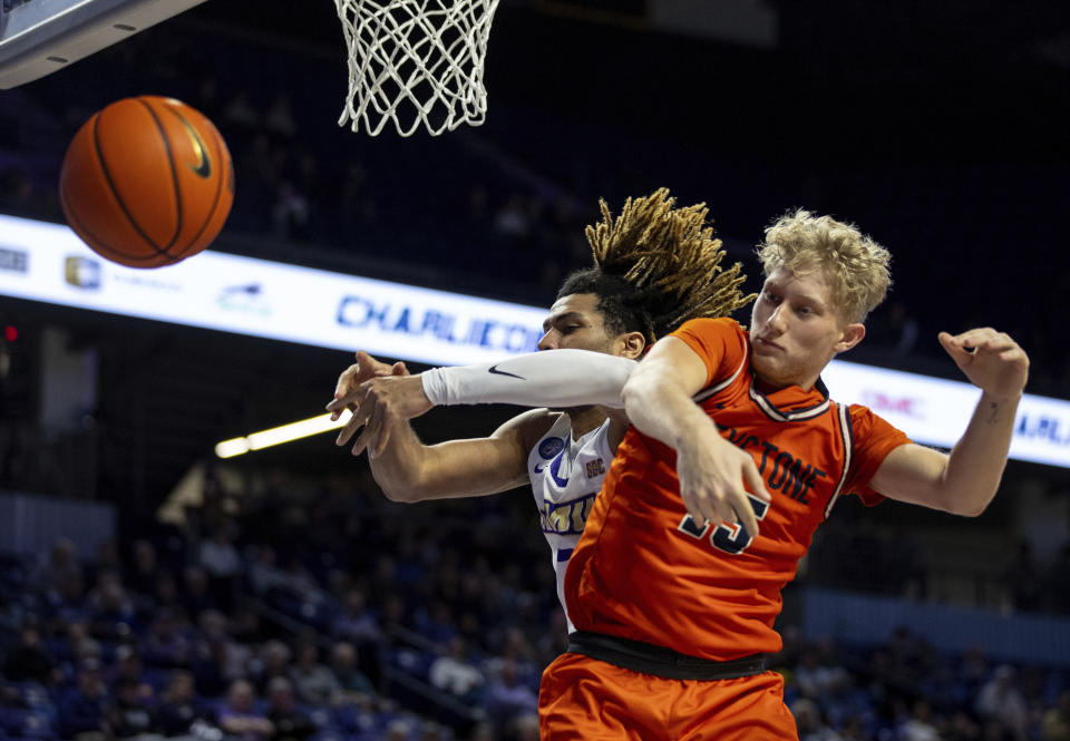 The ball pops loose as James Madison forward T.J. Bickerstaff, left, and Keystone guard Jack Anderson battle for a rebound during the first half of an NCAA college basketball game in Harrisonburg, Va., Sunday, Dec. 3, 2023. (Daniel Lin/Daily News-Record via AP)