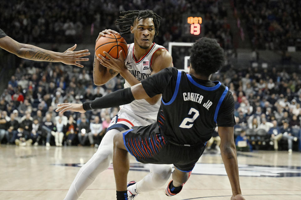 UConn guard Stephon Castle (5) fouls DePaul guard Chico Carter Jr. (2) in the first half of an NCAA college basketball game, Tuesday, Jan. 2, 2024, in Storrs, Conn. (AP Photo/Jessica Hill)