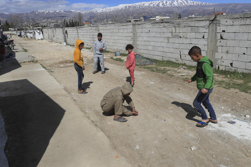 Syrian displaced children play marbles outside their tents at a refugee camp in Bar Elias, Bekaa Valley, Lebanon, Friday, March 5, 2021. UNICEF said Wednesday, March 10, 2021 that Syria’s 10-year-long civil war has killed or wounded about 12,000 children and left millions out of school in what could have repercussions for years to come in the country. The country's bitter conflict has killed nearly half a million people, wounded more than a million and displaced half the country’s population, including more than 5 million as refugees. (AP Photo/Hussein Malla)