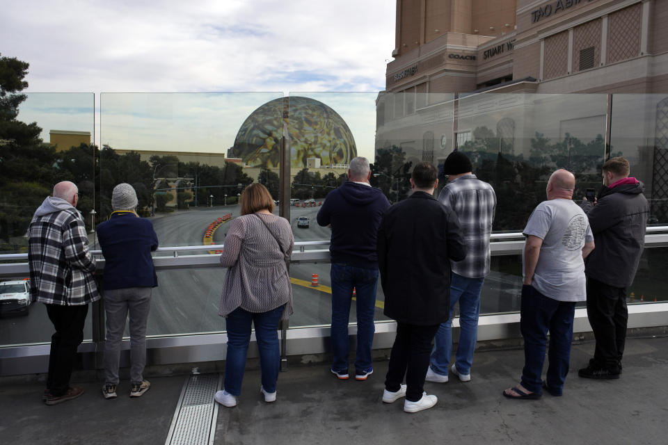 FILE - People stop to take pictures of the Sphere on a pedestrian bridge along the Las Vegas Strip, Wednesday, Jan. 17, 2024, in Las Vegas. The American Civil Liberties Union of Nevada announced Friday, Feb. 16, that it had filed a legal challenge to a controversial ban on stopping or standing on Las Vegas Strip pedestrian bridges. (AP Photo/John Locher, File)