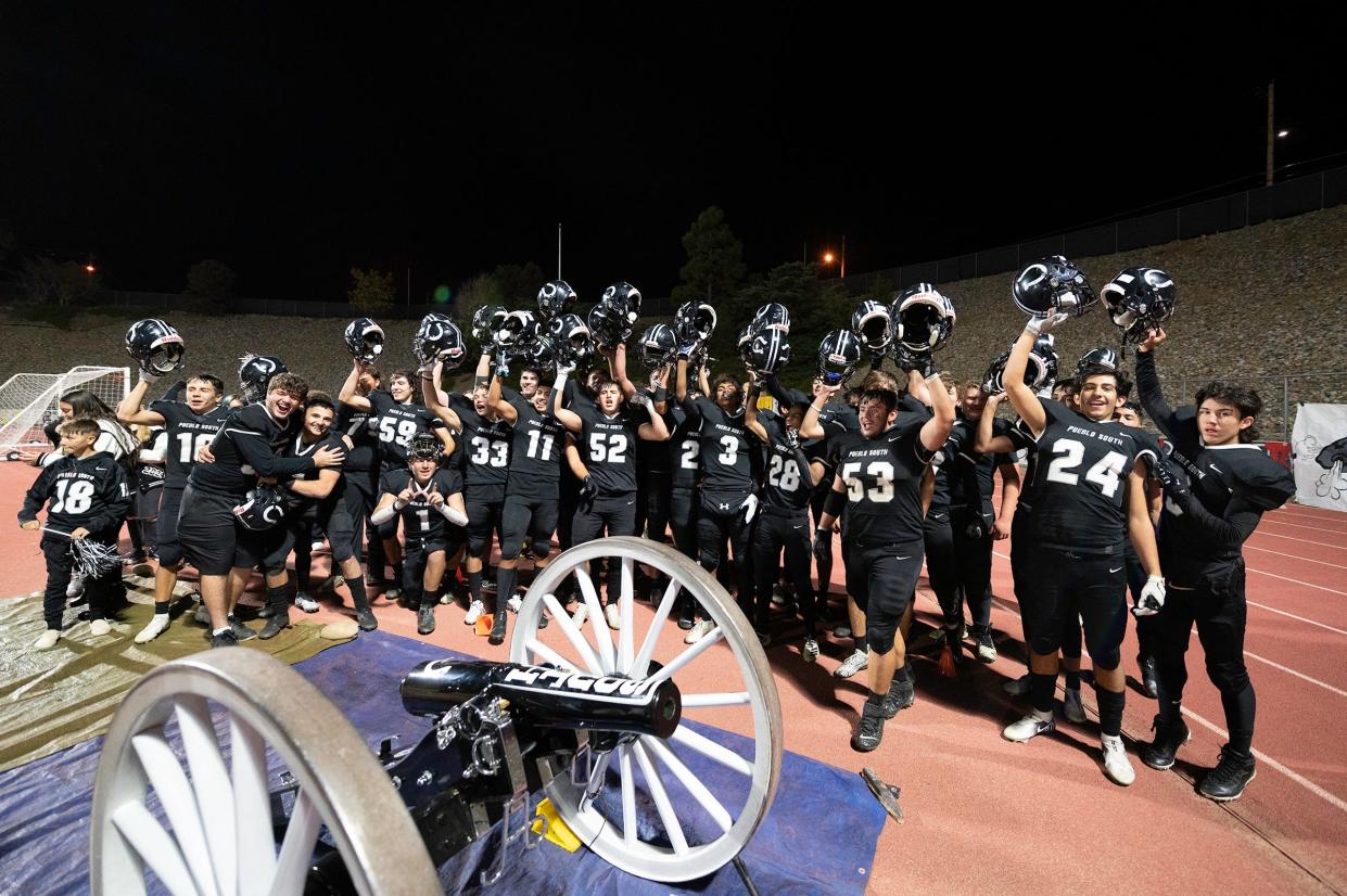 The Pueblo South High School football team celebrate at the cannon after defeating Pueblo East in the 2021 Cannon Game at Dutch Clark Stadium on Friday, October 22, 2021.
