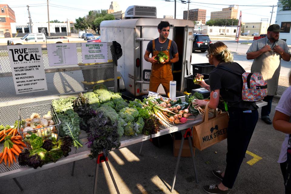 Shoppers peruse the True Local stand at the Abilene Farmer's Market May 14.