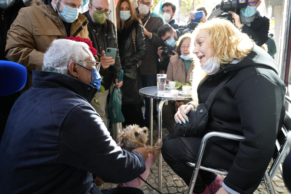 Portuguese Prime Minister and Socialist Party Secretary General Antonio Costa pats a dog while talking to people at a cafe during an election campaign event in the outskirts of Lisbon, Thursday, Jan. 27, 2022. Portugal holds a general election on Jan. 30. (AP Photo/Armando Franca)