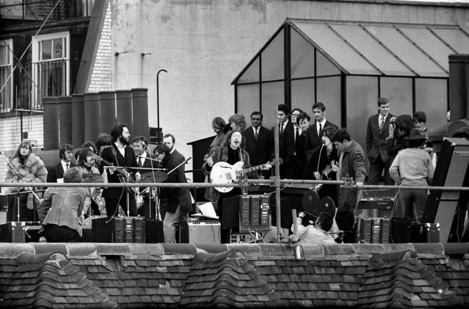 LONDON - January 30:  (L-R) American photographer Linda McCartney (1941-1998) sitting beside English musician, singer and drummer Ringo Starr, English singer-songwriter and multi-instrumentalist Paul McCartney, English musician, singer-songwriter and guitarist George Harrison (1943-2001), and English singer, songwriter and guitarist John Lennon (1940-1980) of the Beatles as they play their final live performance on the roof of 3 Savile Row, Apple Corps headquarters, January 30, 1969 in London, United Kingdom. (Photo by Jeff Hochberg/Getty Images)