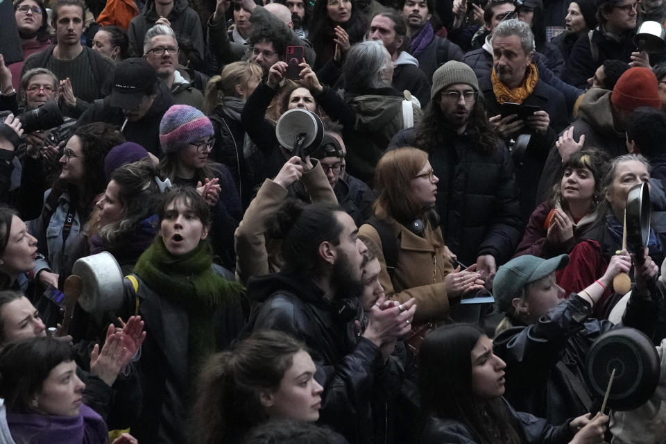 People demonstrate with pans after French President Emmanuel Macron tried to diffuse tensions in a televised address to the nation, Monday, April 17, 2023 in Paris. Emmanuel Macron said Monday that he heard people's anger over raising the retirement age from 62 to 64, but insisted that it was needed. In an televised address to the nation, Macron said "this changes were needed to guarantee everyone's pension," after he enacted the pension law on Saturday. (AP Photo/Thibault Camus)