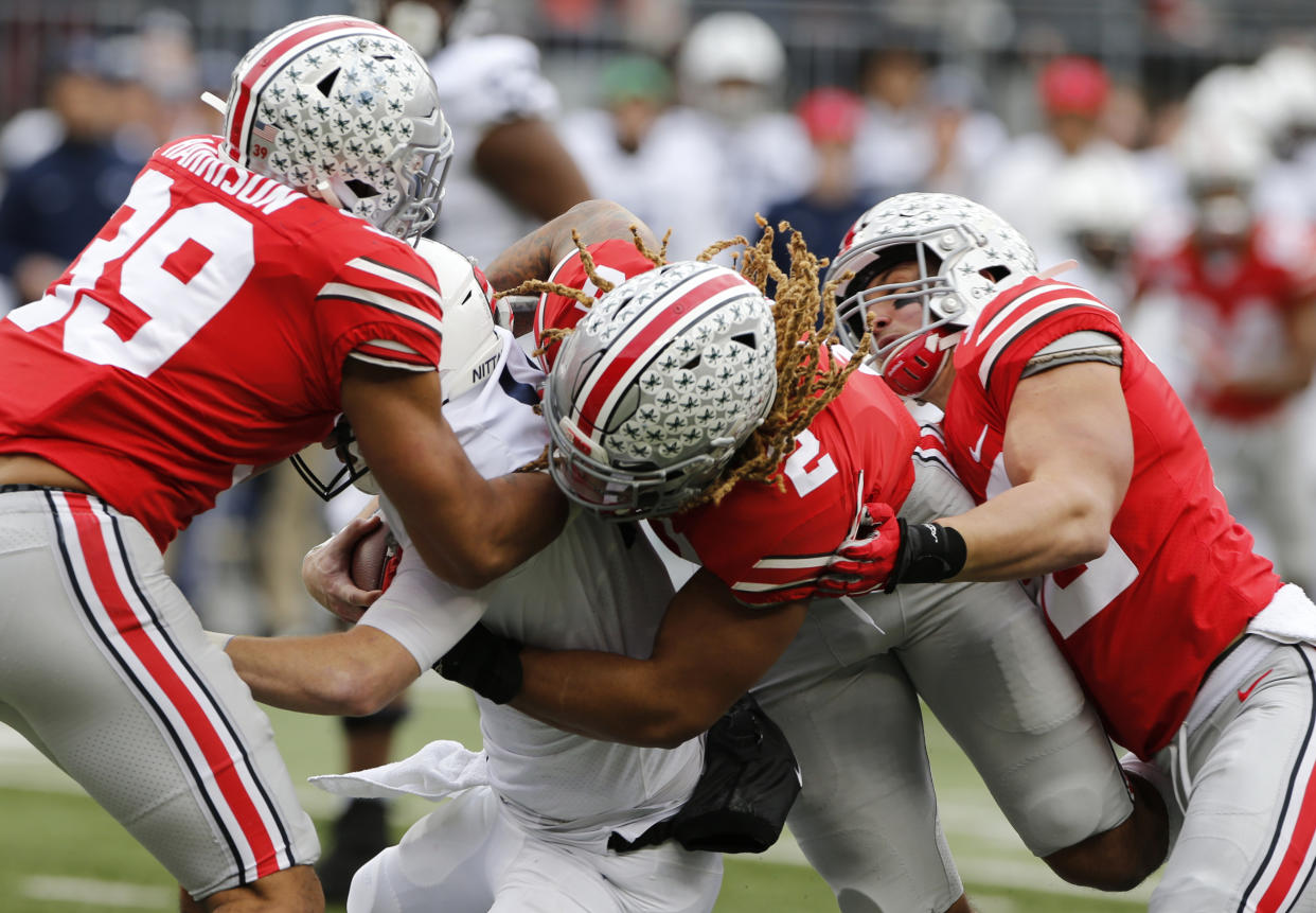 Ohio State defenders, left to right, Malik Harrison, Chase Young and Tuf Borland sack Penn State quarterback Sean Clifford during the first half. (AP)