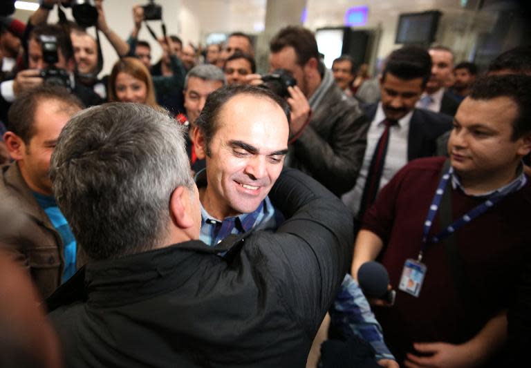 Turkish journalist and photographer Bunyamin Aygun (C) is welcomed by his friends and relatives at the Ataturk airport in Istanbul on January 6, 2014