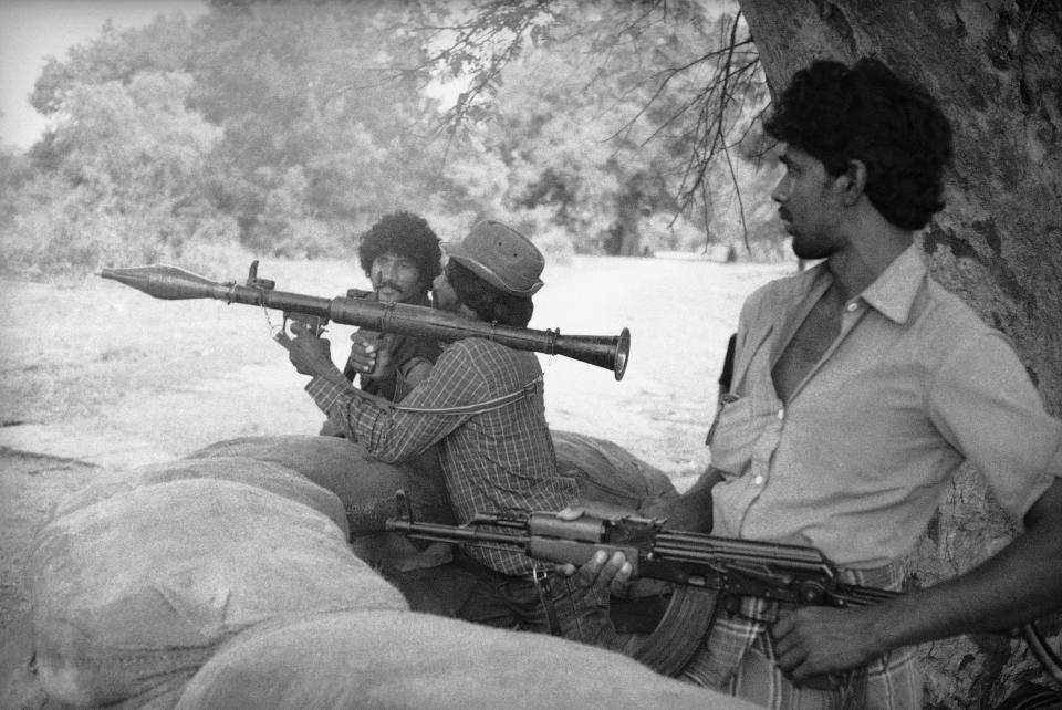 FILE - This Oct. 2, 1987, file photo shows Tamil rebels from the Peoples Liberation Organization of Tamils armed with rifles and rocket launchers on guard in northern Vavuniya town, Sri Lanka. The Indian Ocean island nation of Sri Lanka, which will elect a new president on Saturday, Nov. 16, 2019 has had a tumultuous history. Since gaining independence from British colonial rule in 1948, the country has seen three major armed conflicts in which hundreds of thousands have died. It also has had its share of natural disasters.As it prepares to elect its seventh president, Sri Lanka remains a divided nation, with ethnic, political and economic issues unresolved. (AP Photo/File)