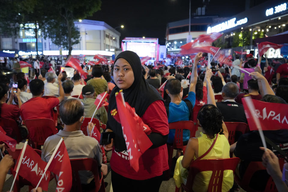 A Pakatan Harapan (Alliance of Hope) coalition volunteer gives out flags during an election rally in Kuala Lumpur, Malaysia, Wednesday, Nov. 16, 2022. Malaysia's general elections will take place Saturday, over a month after Prime Minister Ismail Sabri Yaakob dissolved Parliament and announced snap elections. The country's longest-serving coalition is seeking to regain its dominance after a shocking loss in 2018, but political reformers are aiming for a second surprise win. (AP Photo/Vincent Thian)