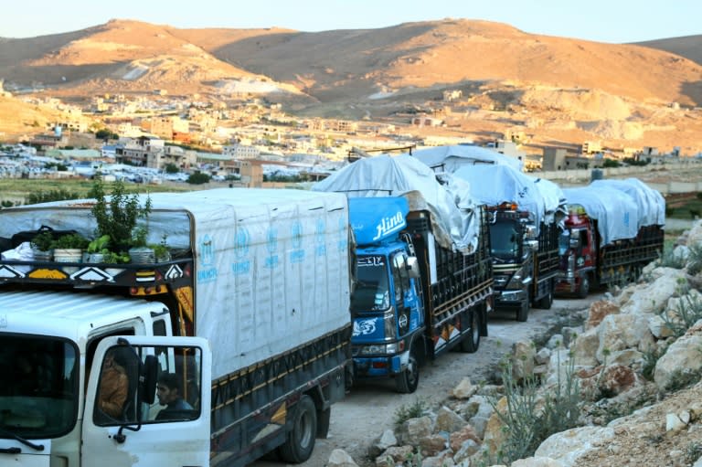 Syrian refugees head home from Lebanon in a convoy of trucks piled high with their belongings (-)